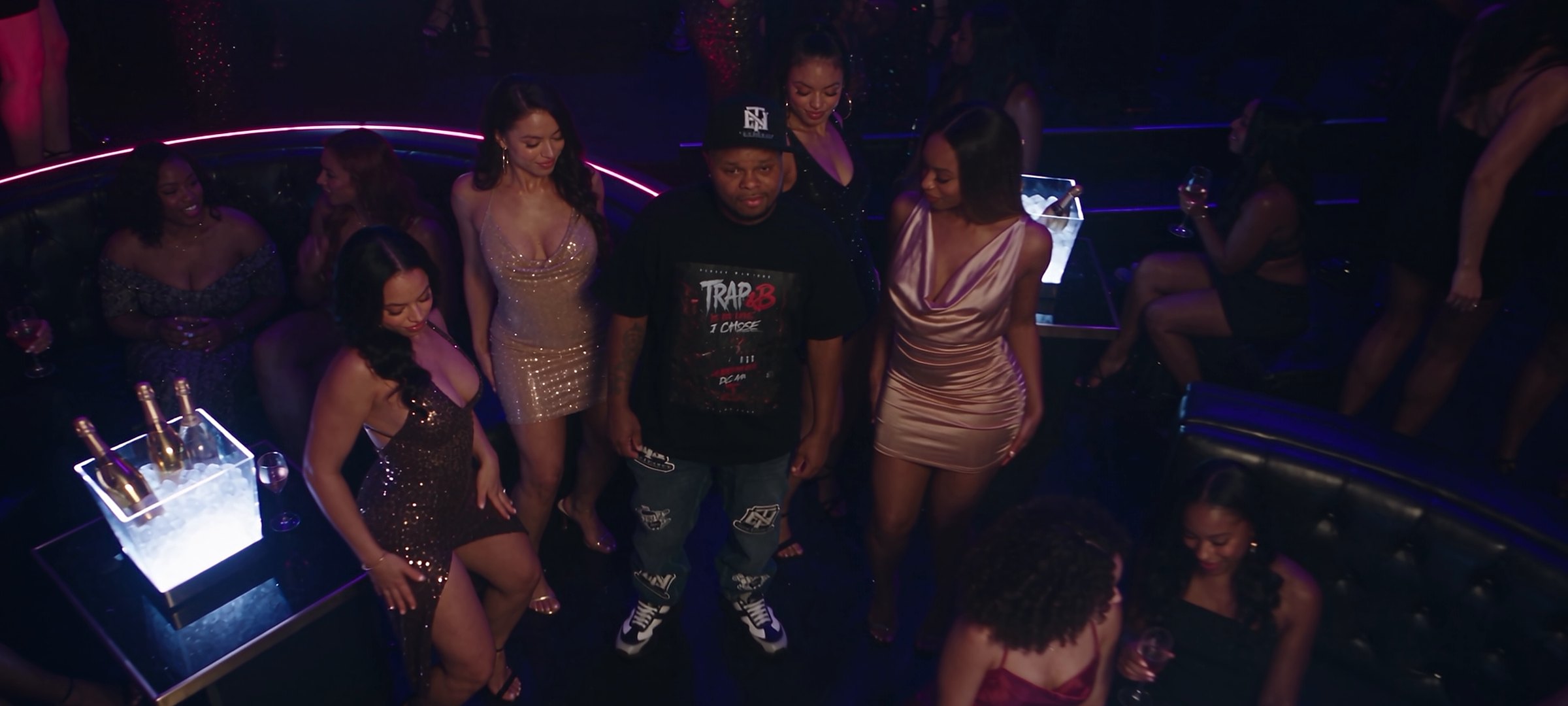 Dinero Montaro in a nightclub surrounded by women, from the 7 Days video